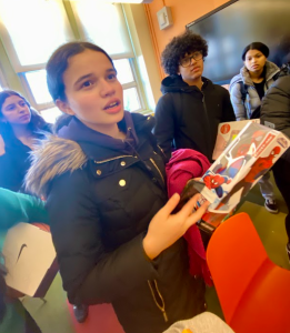 High School age students hold presents.
