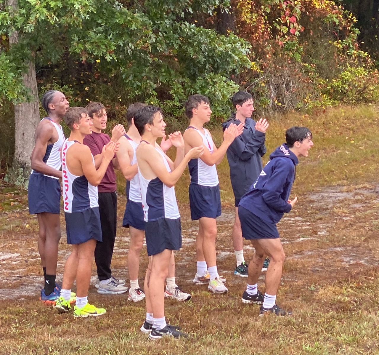 Young men face to the right cheering for the race.