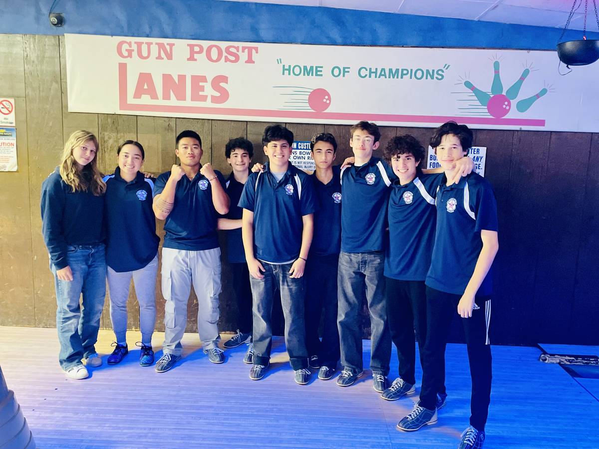 Members of the Bowling stand side by side with their arms over one another.