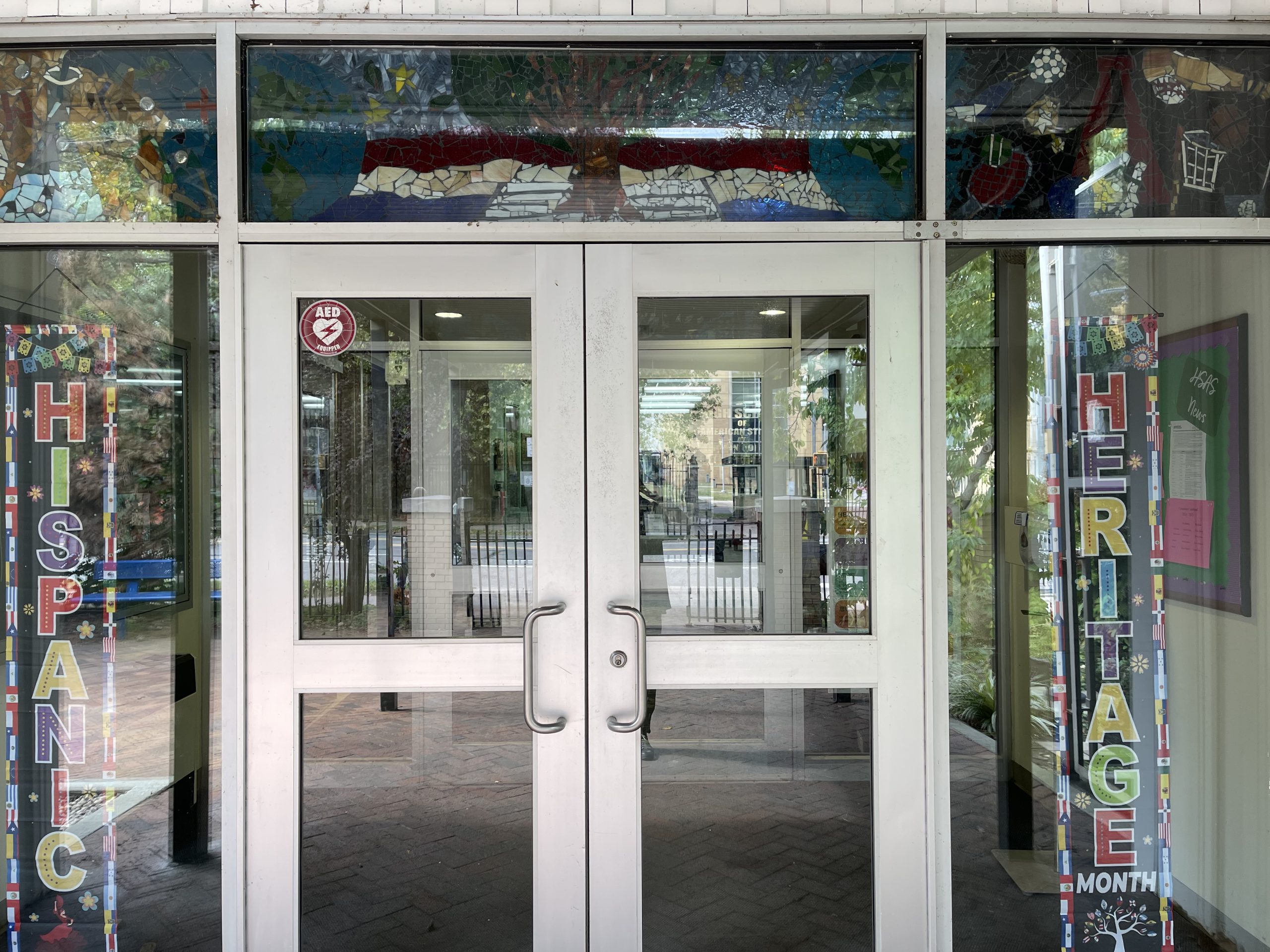 The Front Doors of a school building with signage reading "Hispanic Heritage"