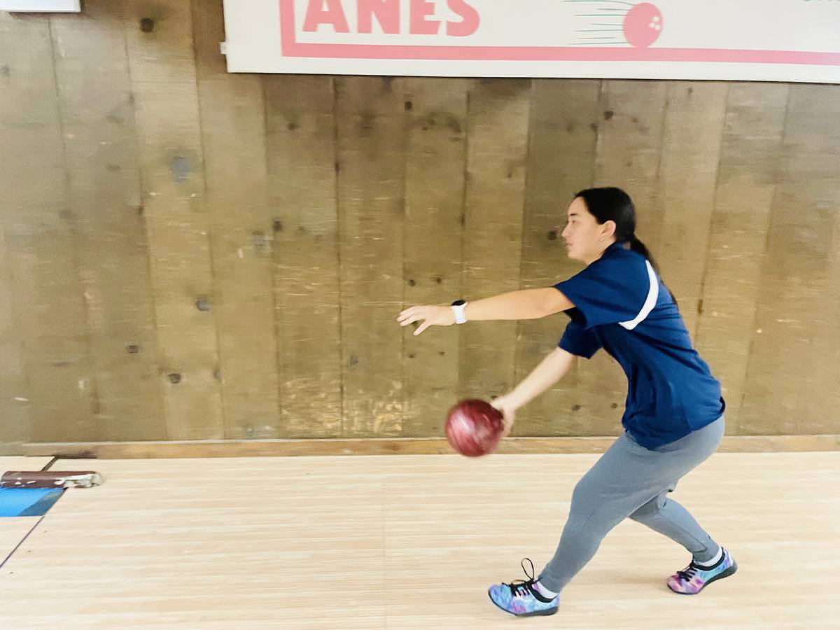 Student bowls a bowling ball.