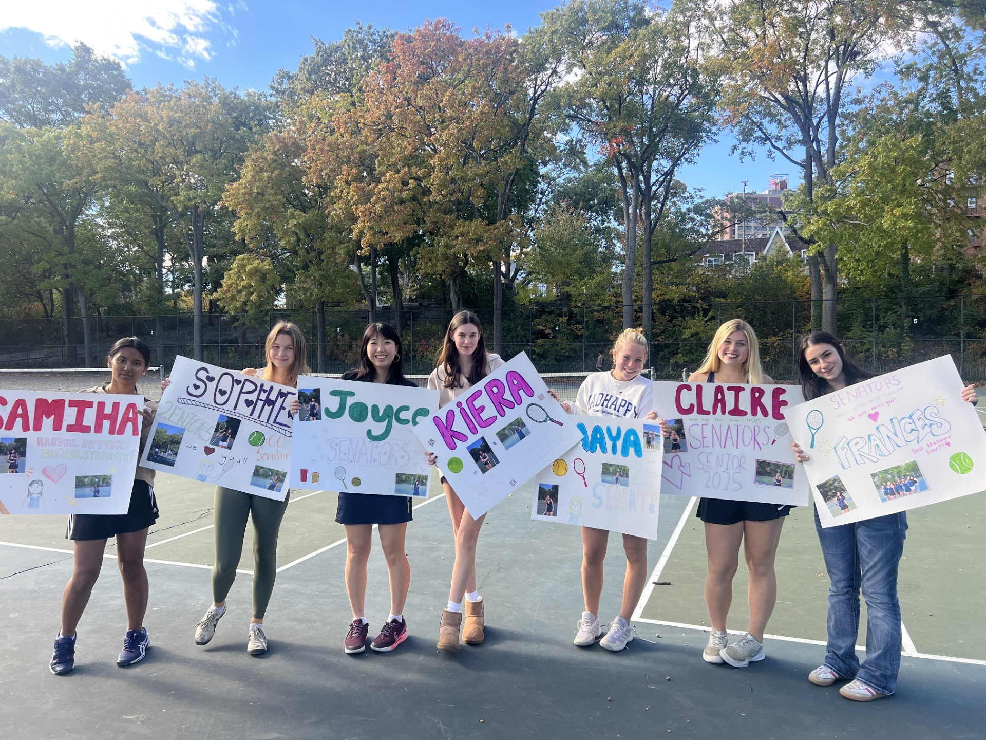 Members of the team hold up signs,