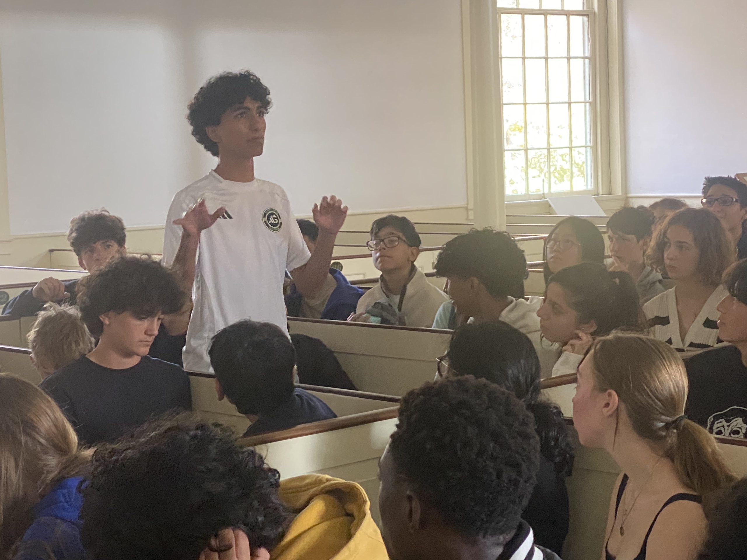 Student stands in front of classmates.