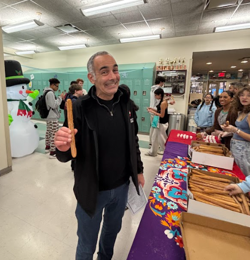 Man holds churro and smiles