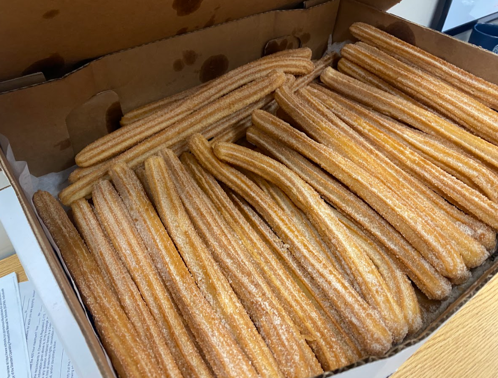 An open box filled with dozens of churros