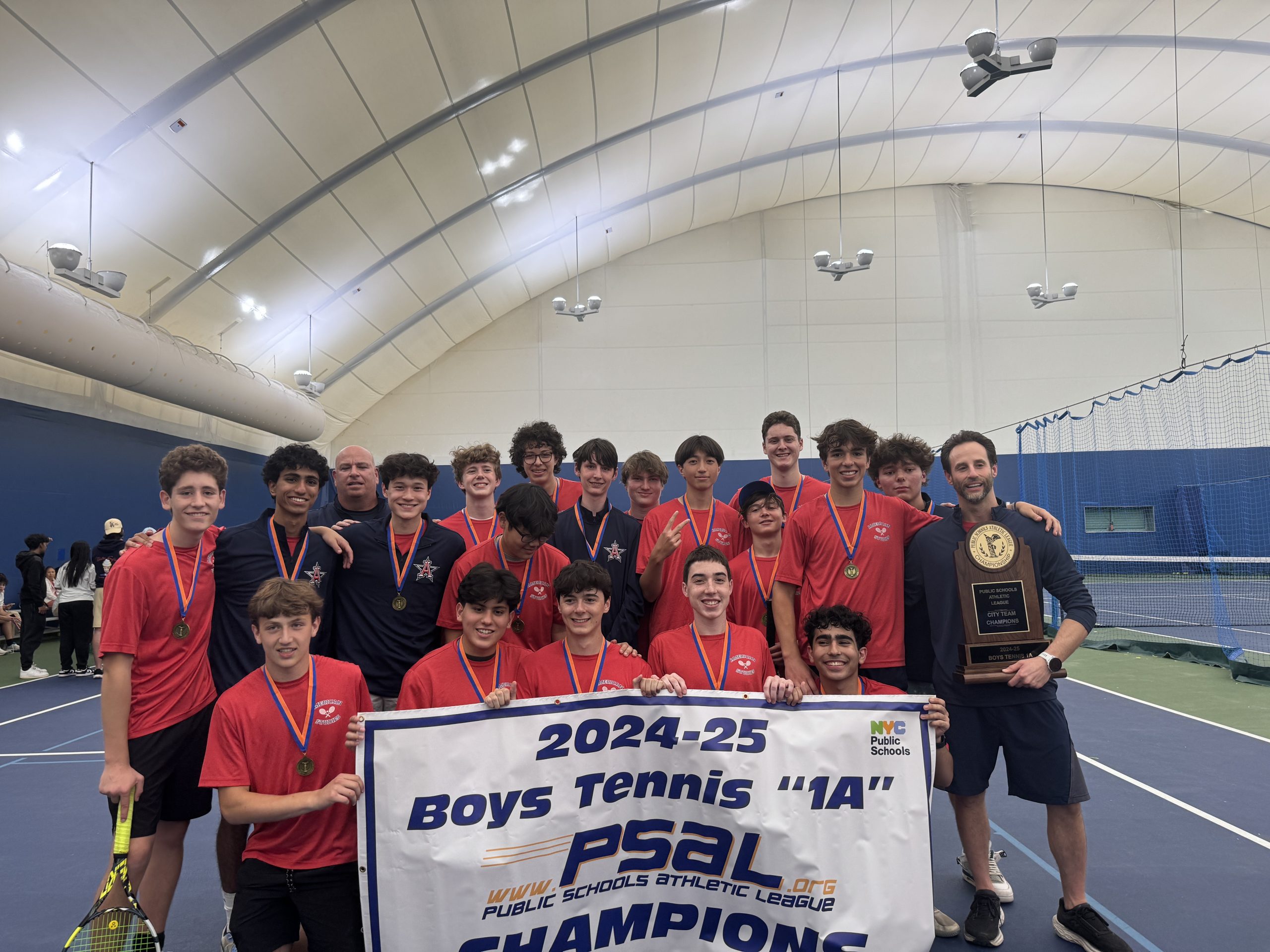 Members of the Boys Tennis Team stand with a banner reading "City Champions".