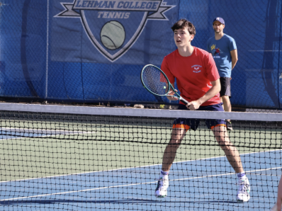 Player stands ready with a racquet at the the net