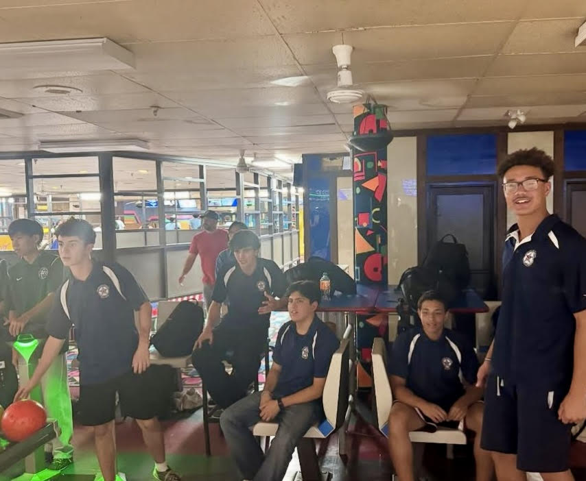 Members of the Bowling Team sit in a bowling alley