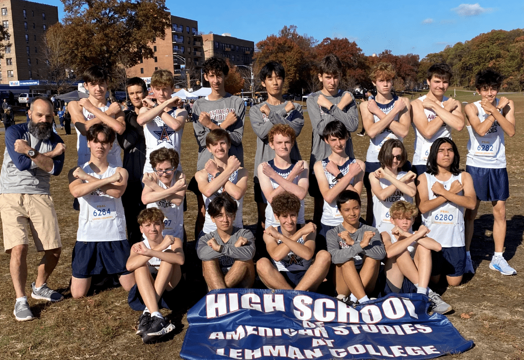 Members of the Running Team pose in three rows making an X signal with their arms.