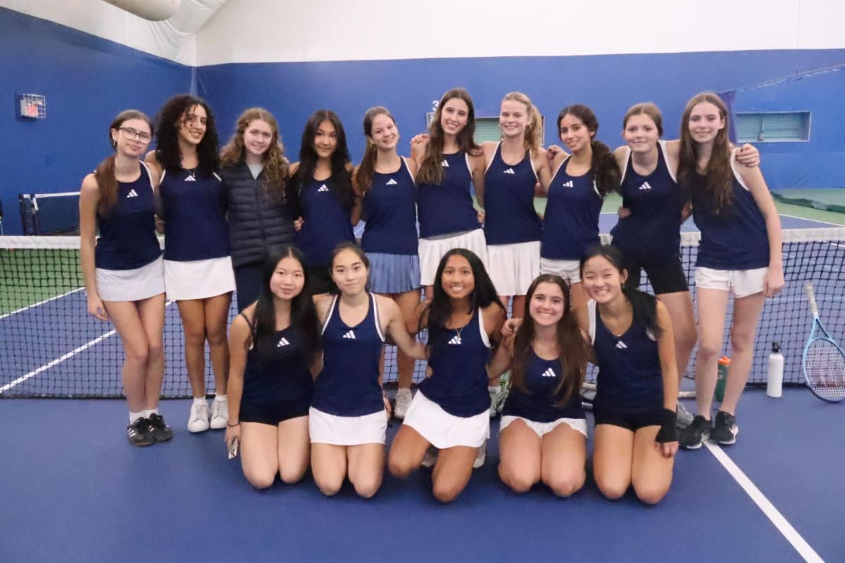 Members of the girls tennis team pose in two rows standing side by side.