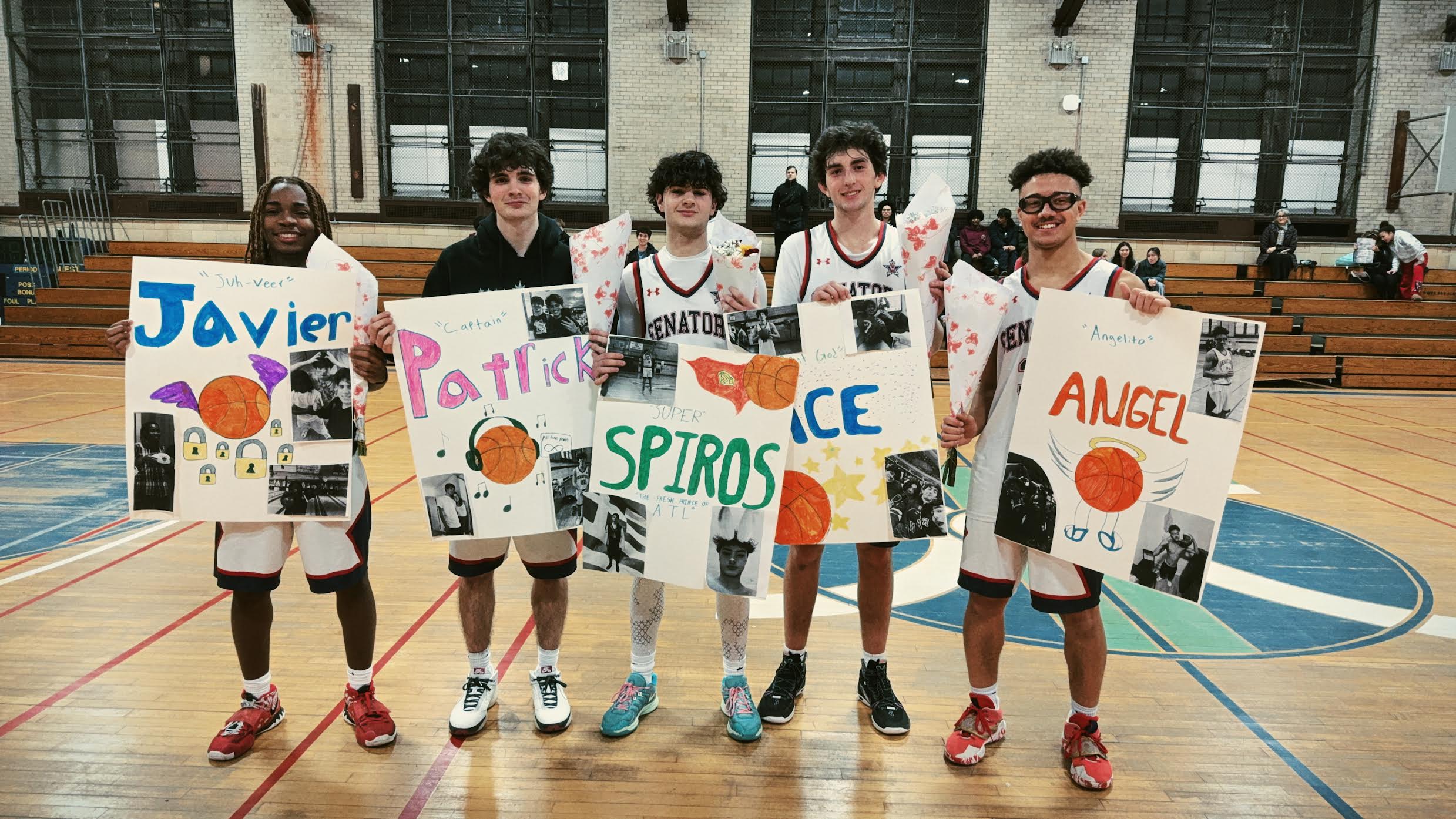 Five players stand shoulder to shoulder in uniform holding signs.
