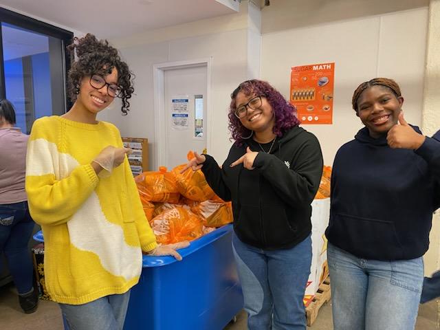 Three students are loading food baskets