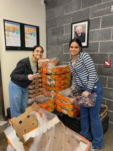 Two students are loading food baskets