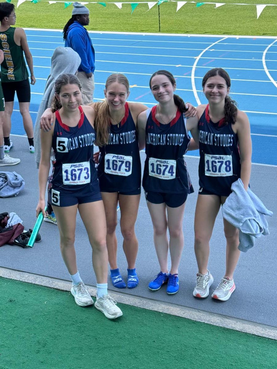 Girls on the relay team stand side by side holding a baton