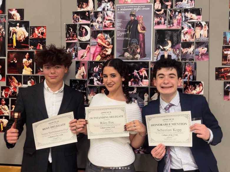 Three students in suits stand side by side