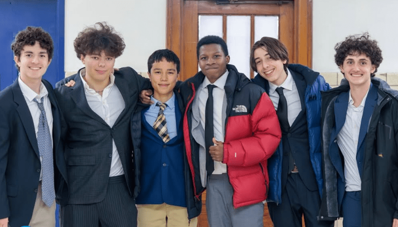 Four students in suits stand side by side